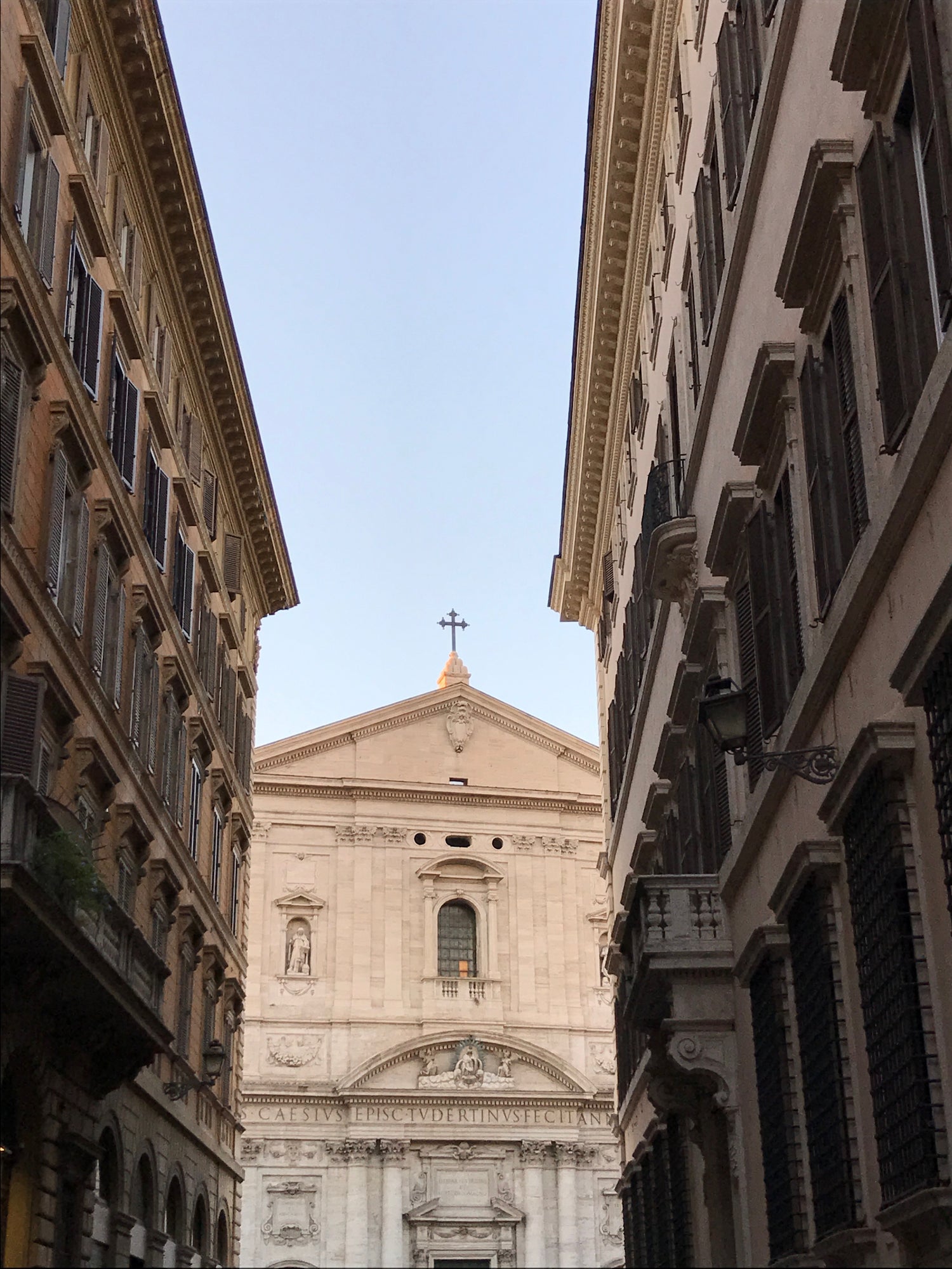 Roma building facades and church under a bright blue sky
